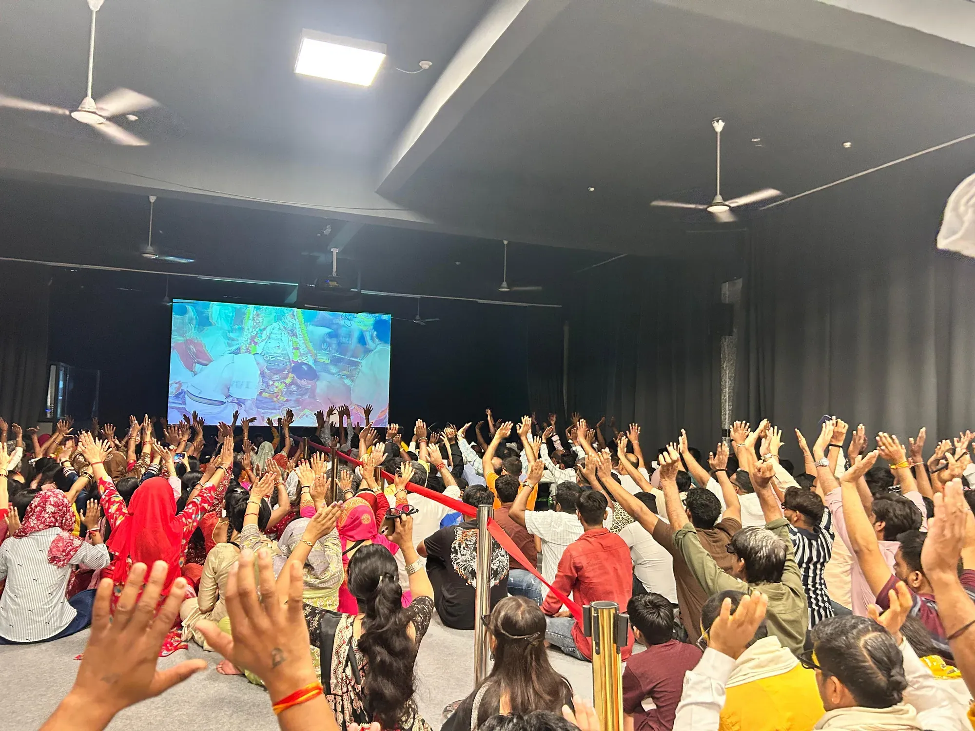Devotees with raised hands during the aarti